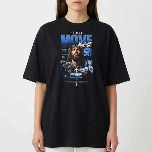 Camiseta com estampa frontal de figura de homem com cruz ao fundo, cercado por montanhas e frase "Fé que move montanhas".