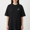 Camiseta com estampa frontal de logo minimalista circular e estampa traseira de skatista sobre ruínas urbanas e círculo abstrato.