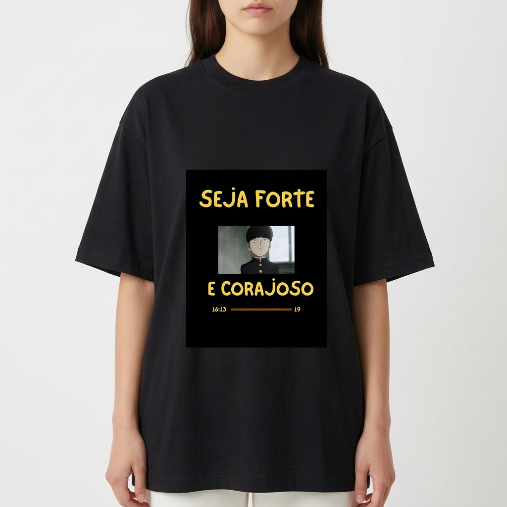 Camiseta com estampa frontal de personagem de cabelo curto em estilo desenho animado com mensagem inspiradora "SEJA FORTE E CORAJOSO" em letras destacadas.