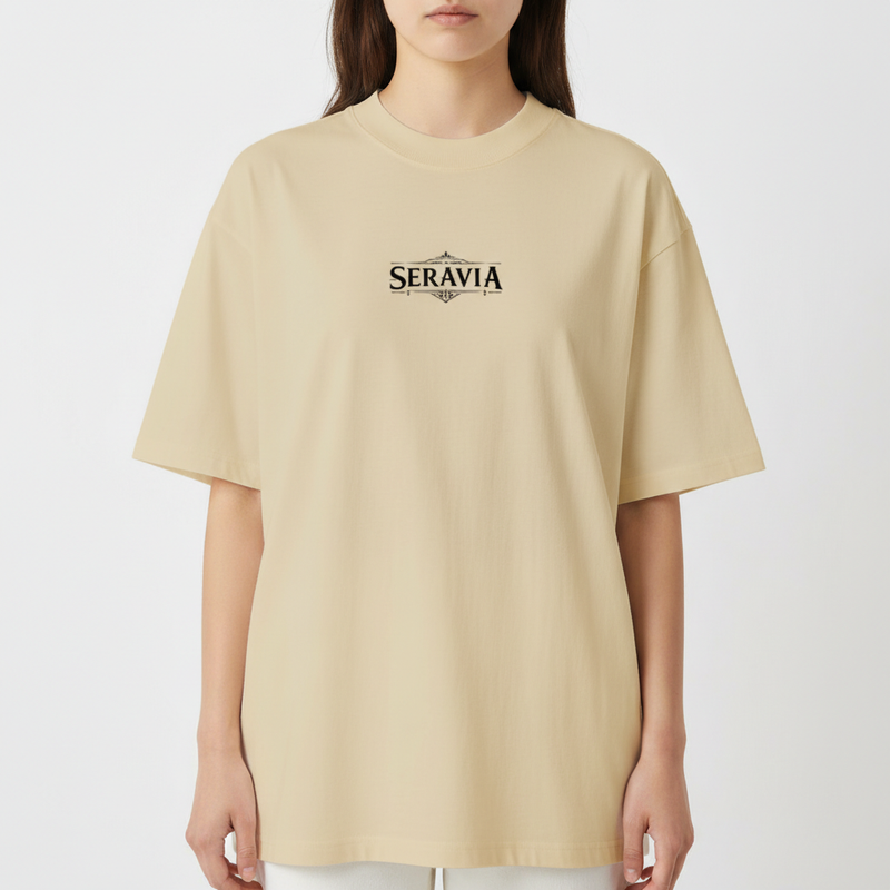 Camiseta com estampa frontal de "Seravia" estilizado e estampa traseira de espadas cruzadas sob asas abertas com símbolo circular no topo.