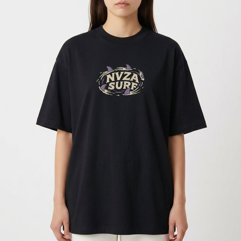 Camiseta com estampa frontal de texto centralizado "NVZA SURF" rodeado por um desenho de tubarões que criam forma circular em torno das letras.