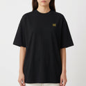 Camiseta com estampa frontal do monograma "H" minimalista e estampa traseira de imagem artística com mãos semelhantes a "A Criação" e texto "Born from Caffeine".