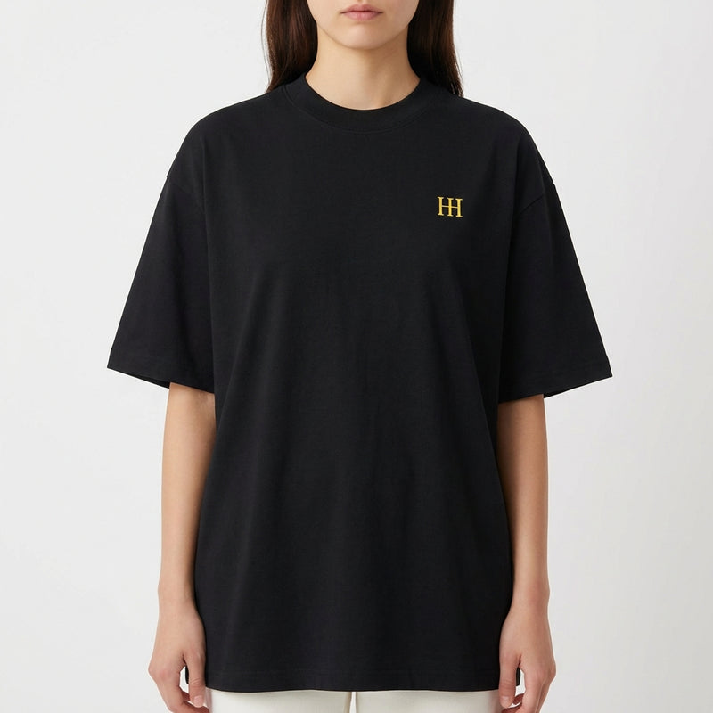 Camiseta com estampa frontal do monograma "H" minimalista e estampa traseira de imagem artística com mãos semelhantes a "A Criação" e texto "Born from Caffeine".