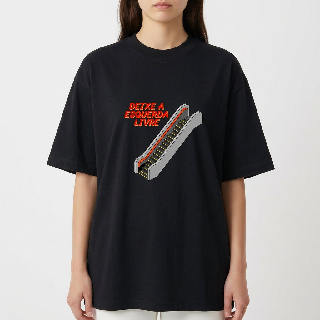 Camiseta com estampa frontal de escada rolante e frase "DEIXE A ESQUERDA LIVRE", em estilo tipográfico destacado ao lado da ilustração.