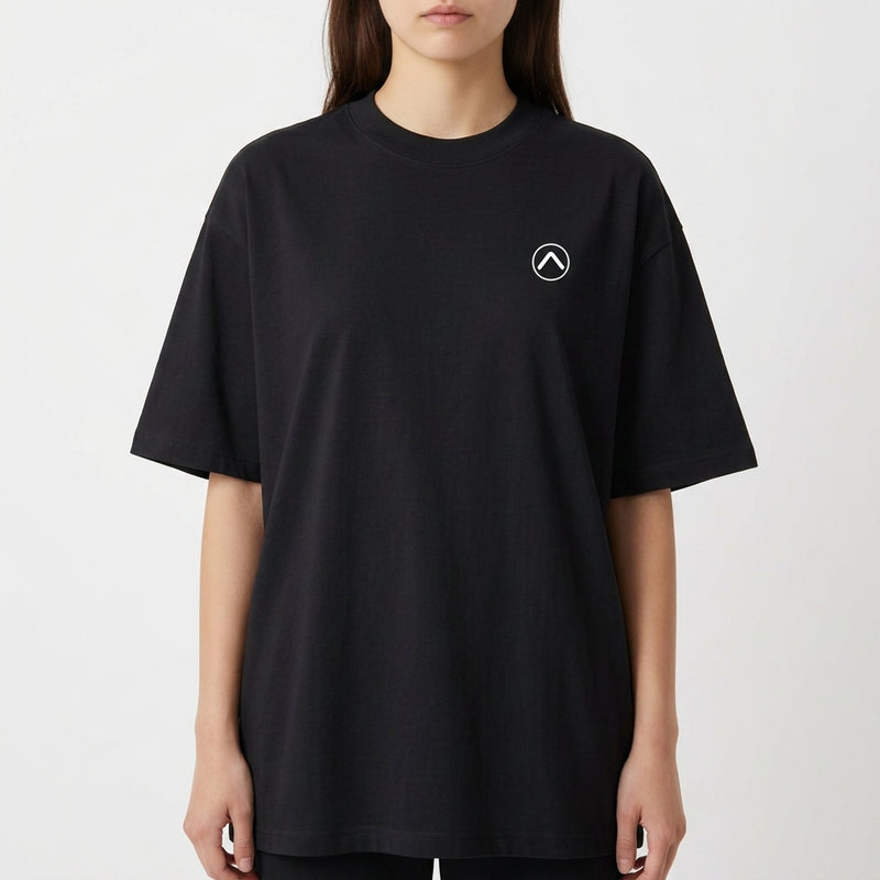 Camiseta com estampa frontal de símbolo minimalista circular com seta apontando para cima e estampa traseira de paisagem tropical com palmeiras e pôr do sol refletido no mar.