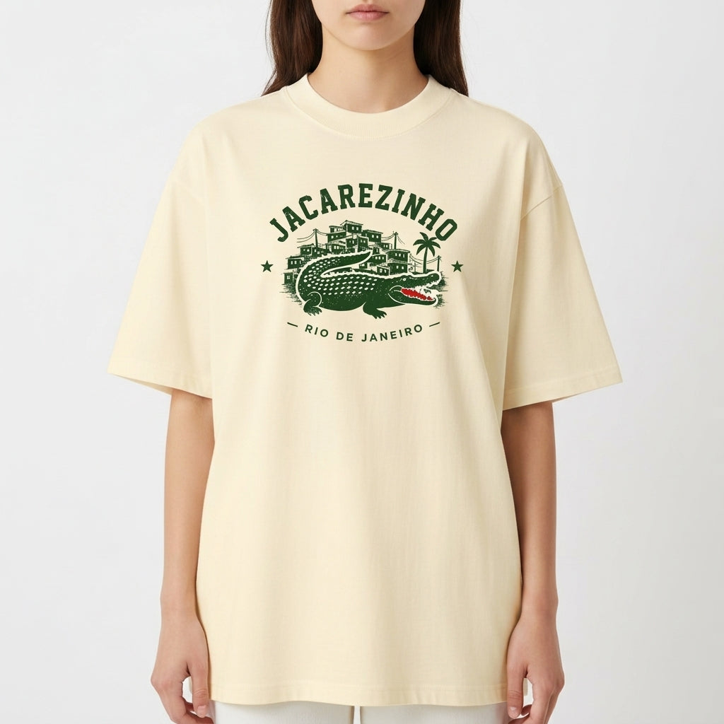 Camiseta com estampa frontal de Jacarezinho, mostrando um crocodilo estilizado com prédios e palmeiras ao fundo, acompanhada das palavras "Rio de Janeiro".