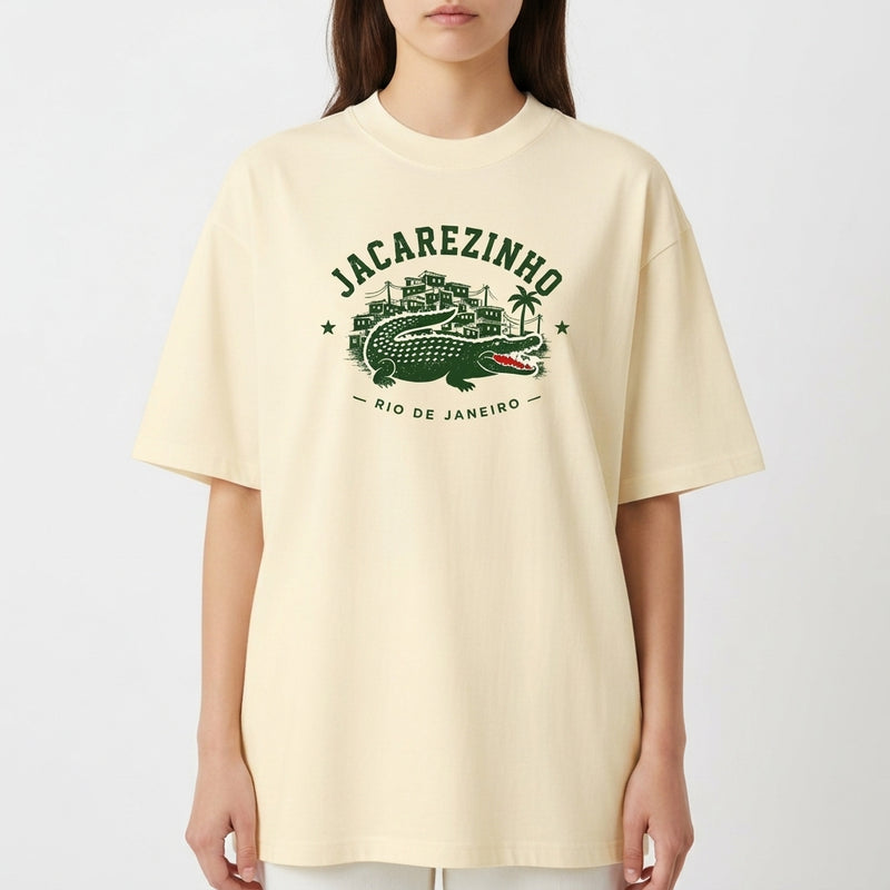 Camiseta com estampa frontal de Jacarezinho, mostrando um crocodilo estilizado com prédios e palmeiras ao fundo, acompanhada das palavras "Rio de Janeiro".