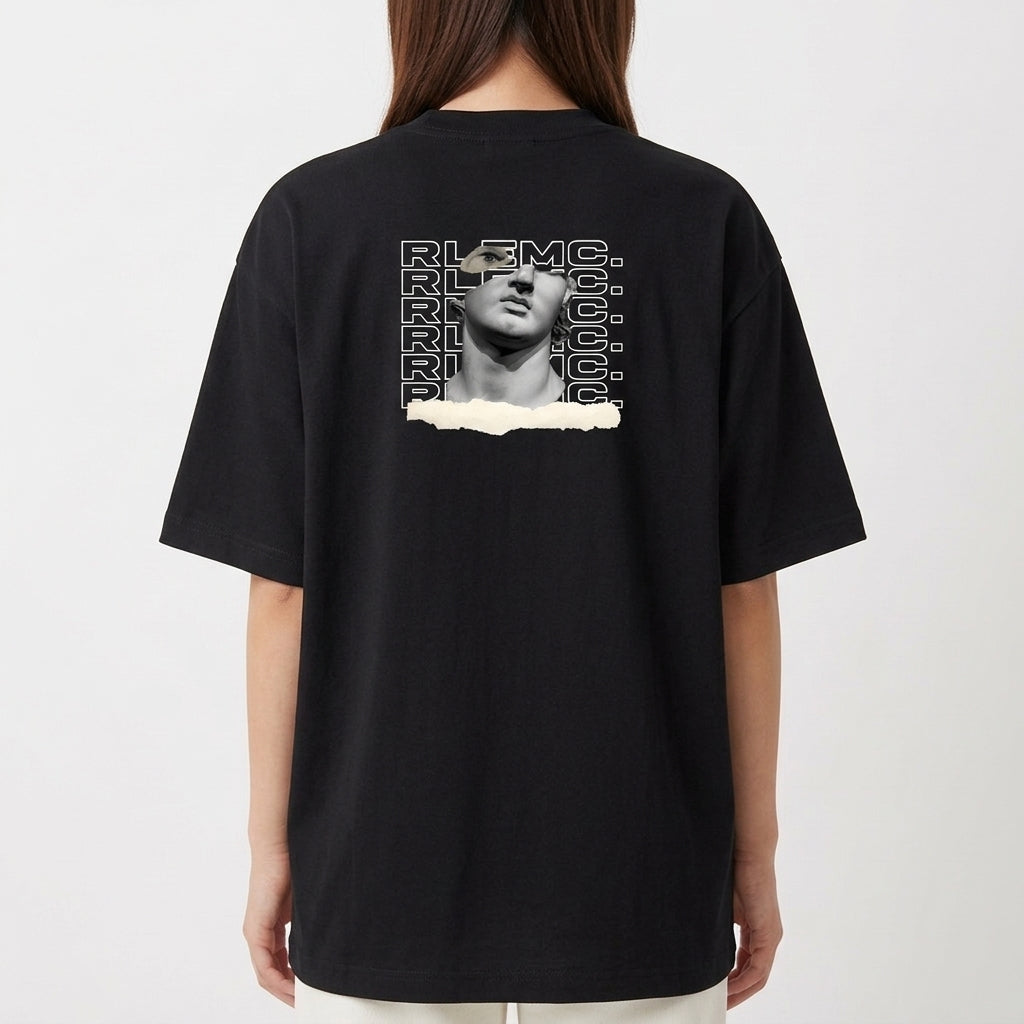 Camiseta com estampa frontal de uma escultura clássica com texto estilizado repetido e detalhe de rasgo, e estampa traseira similar ampliada e centralizada.