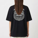Camiseta com estampa traseira de figura mitológica musculosa levantando halteres, cercada por ornamentos clássicos e a inscrição "Iron Discipline".