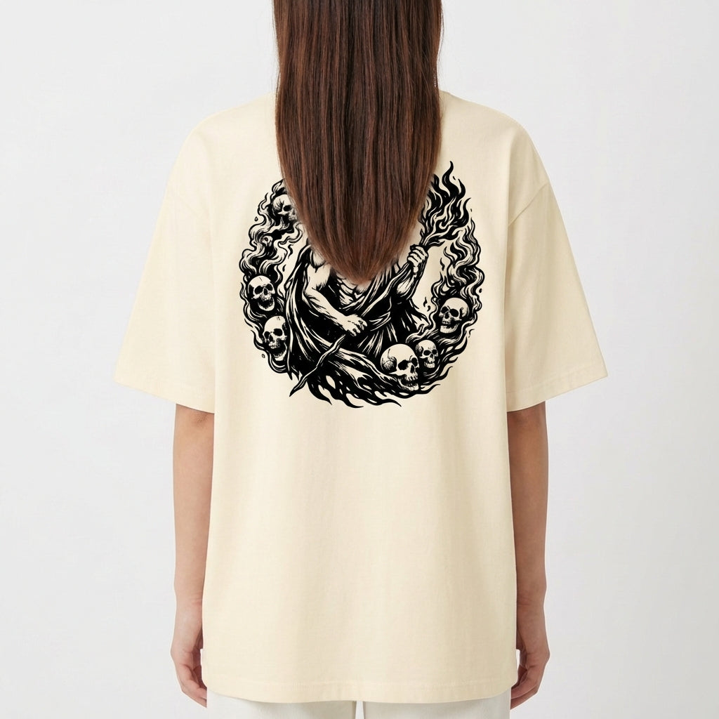 Camiseta com estampa frontal de montanha e texto sob ela, e estampa traseira detalhada de figura mitológica central cercada por caveiras e chamas.