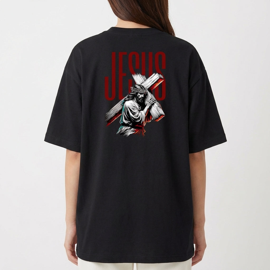 Camiseta com estampa frontal de uma estrutura arqueológica e estampa traseira de figura religiosa carregando uma cruz com a palavra "JESUS" em destaque.