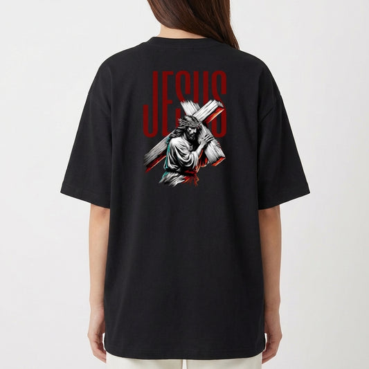 Camiseta com estampa frontal de uma estrutura arqueológica e estampa traseira de figura religiosa carregando uma cruz com a palavra "JESUS" em destaque.