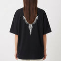 Camiseta com estampa traseira de uma cruz estilizada com asas detalhadas, onde os traços lembram penas e se entrelaçam, formando uma figura imponente.