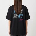Camiseta com estampa frontal de “L5 2C” em estilo pixelizado e texto menor em roxo, e estampa traseira ampliada do mesmo texto com caracteres adicionais.