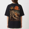 Camiseta com estampa frontal de símbolo minimalista no canto inferior e estampa traseira de paisagem praiana ao entardecer com padrão de calçada ondulada.