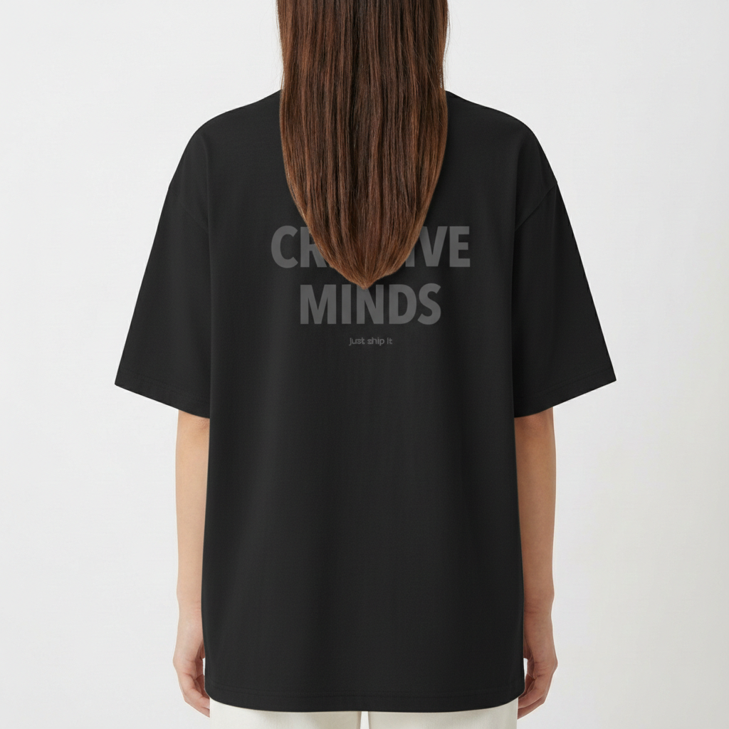 Camiseta com estampa frontal de texto "WE ARE CREATIVE MINDS" e estampa traseira maior com mesma frase, acompanhada de texto menor "just ship it".