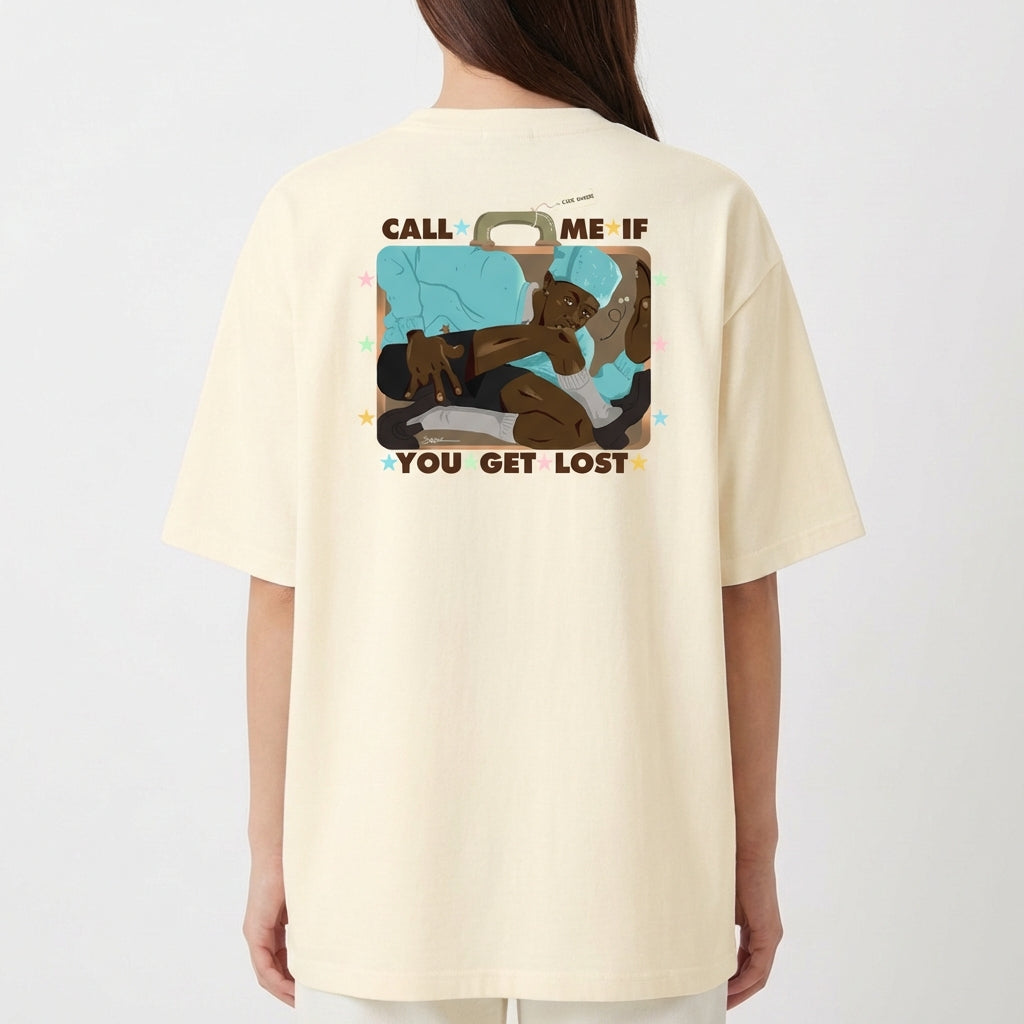 Camiseta com estampa frontal de texto "CALL ME IF YOU GET LOST" adornado com pequenas estrelas coloridas e estampa traseira de ilustração com figura relaxando em mala.