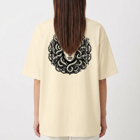 Camiseta com estampa frontal de logo estilizado "SERAVIA" e estampa traseira de figura mitológica com cabelos de serpentes emoldurada por elementos clássicos.