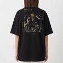 Camiseta com estampa frontal de símbolo estilizado minimalista e estampa traseira de personagem em pose dinâmica cercado por textos e gráficos detalhados.