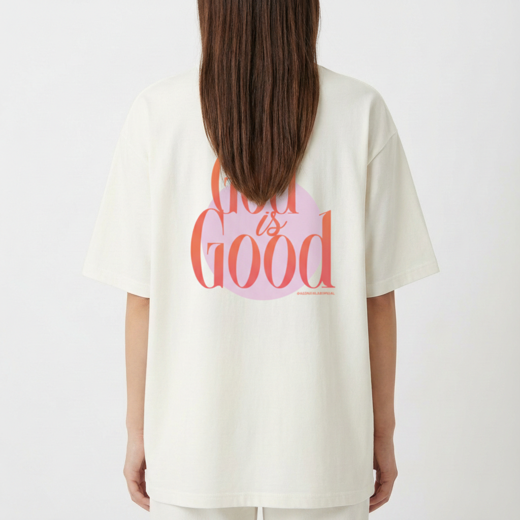 Camiseta com estampa frontal de "lab" em letras vibrantes e detalhes de linhas onduladas, e estampa traseira de "God is Good" sobrepondo um círculo.