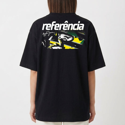 Camiseta com estampa frontal de elementos abstratos estilizados e fragmentos de rosto e estampa traseira de piloto de corrida com capacete e assinatura.