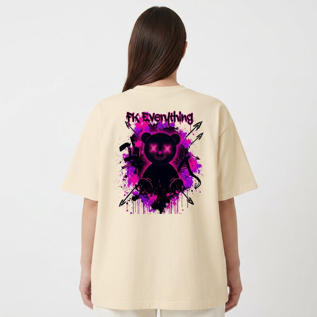 Camiseta com estampa frontal de frase estilizada e estampa traseira de urso com olhos em cruz, fundo de tinta respingada e símbolos de flechas e ferramentas.