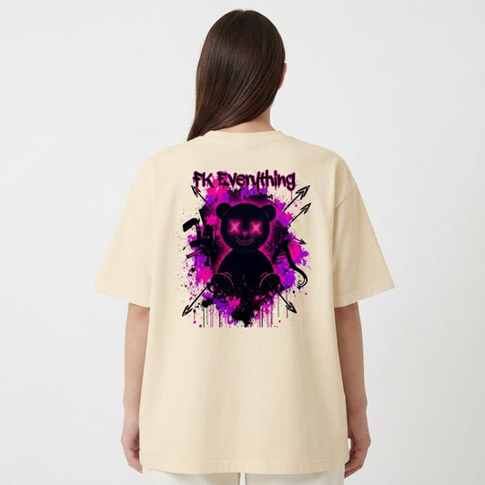 Camiseta com estampa frontal de frase estilizada e estampa traseira de urso com olhos em cruz, fundo de tinta respingada e símbolos de flechas e ferramentas.