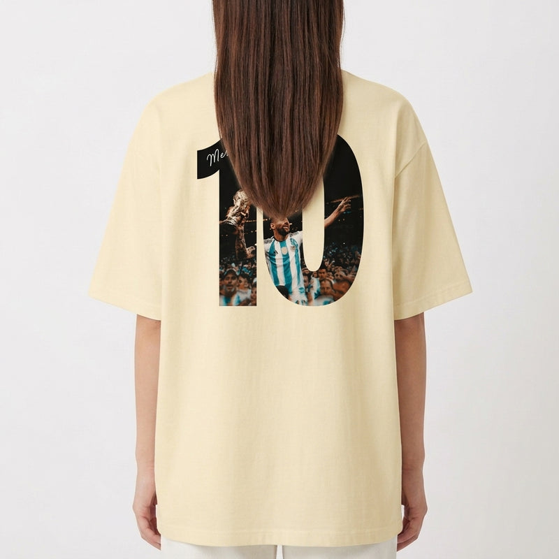 Camiseta com estampa traseira de número grande "10" ilustrando jogador em ação segurando troféu, com assinatura sobreposta e multidão ao fundo.