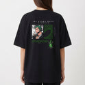 Camiseta com estampa frontal de pequeno logotipo estilizado e estampa traseira de personagem em quadrinhos com frase em destaque e elementos gráficos.