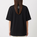 Camiseta com estampa frontal de dois personagens sentados com um dispositivo, um dos personagens sorridente e mãos aos ombros, e estampa traseira de gaiola minimalista com texto pequeno.