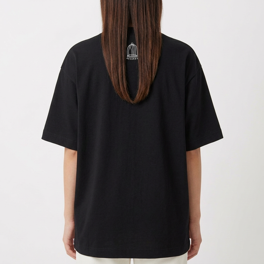 Camiseta com estampa frontal de dois personagens sentados com um dispositivo, um dos personagens sorridente e mãos aos ombros, e estampa traseira de gaiola minimalista com texto pequeno.