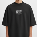 Camiseta com estampa frontal de texto "CREATORS DEPT." em destaque, acompanhada por uma frase menor e logo oval discretamente posicionada abaixo.