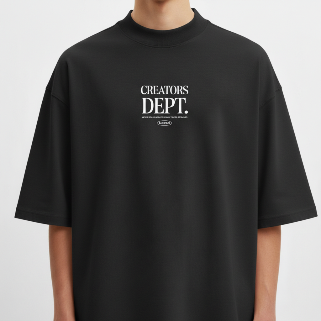 Camiseta com estampa frontal de texto "CREATORS DEPT." em destaque, acompanhada por uma frase menor e logo oval discretamente posicionada abaixo.