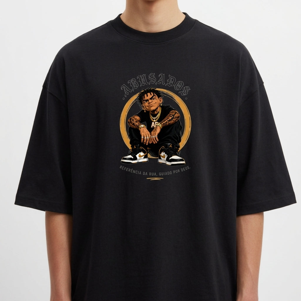 Camiseta com estampa frontal de personagem sentado com tatuagens visíveis, cercado por texto "ABUSADOS" no topo e legenda "REFERÊNCIA DA RUA, CRIADO POR ORIX."