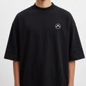 Camiseta com estampa frontal de pequeno emblema circular contendo uma seta direcionada para cima e estampa traseira de grande onda em estilo retrô com sol vermelho.