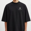 Camiseta com estampa frontal de borboleta pequena e frase "This action will have consequences..." e estampa traseira com figura de pessoa com câmera, texto "STRANGE" em destaque, elementos gráficos e "OREGON 2013".