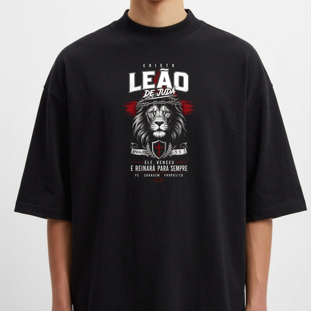 Camiseta com estampa frontal de um leão acompanhado de texto "Cristo Leão de Judá", escudo e datas, destacando simbolismo religioso e força.