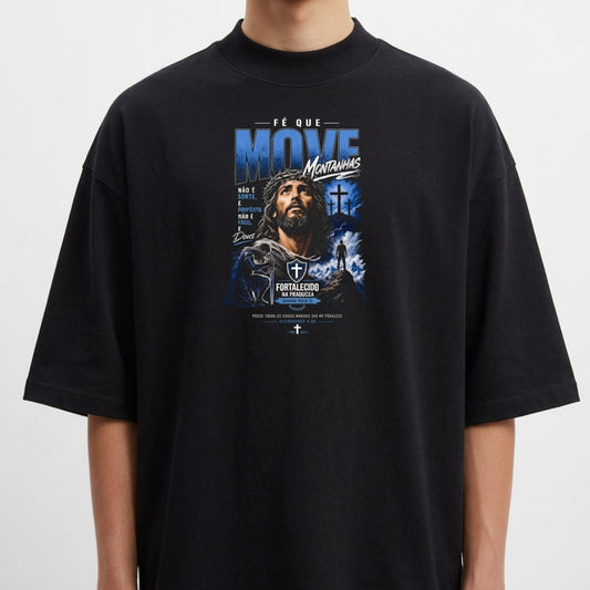 Camiseta com estampa frontal de figura de homem com cruz ao fundo, cercado por montanhas e frase "Fé que move montanhas".