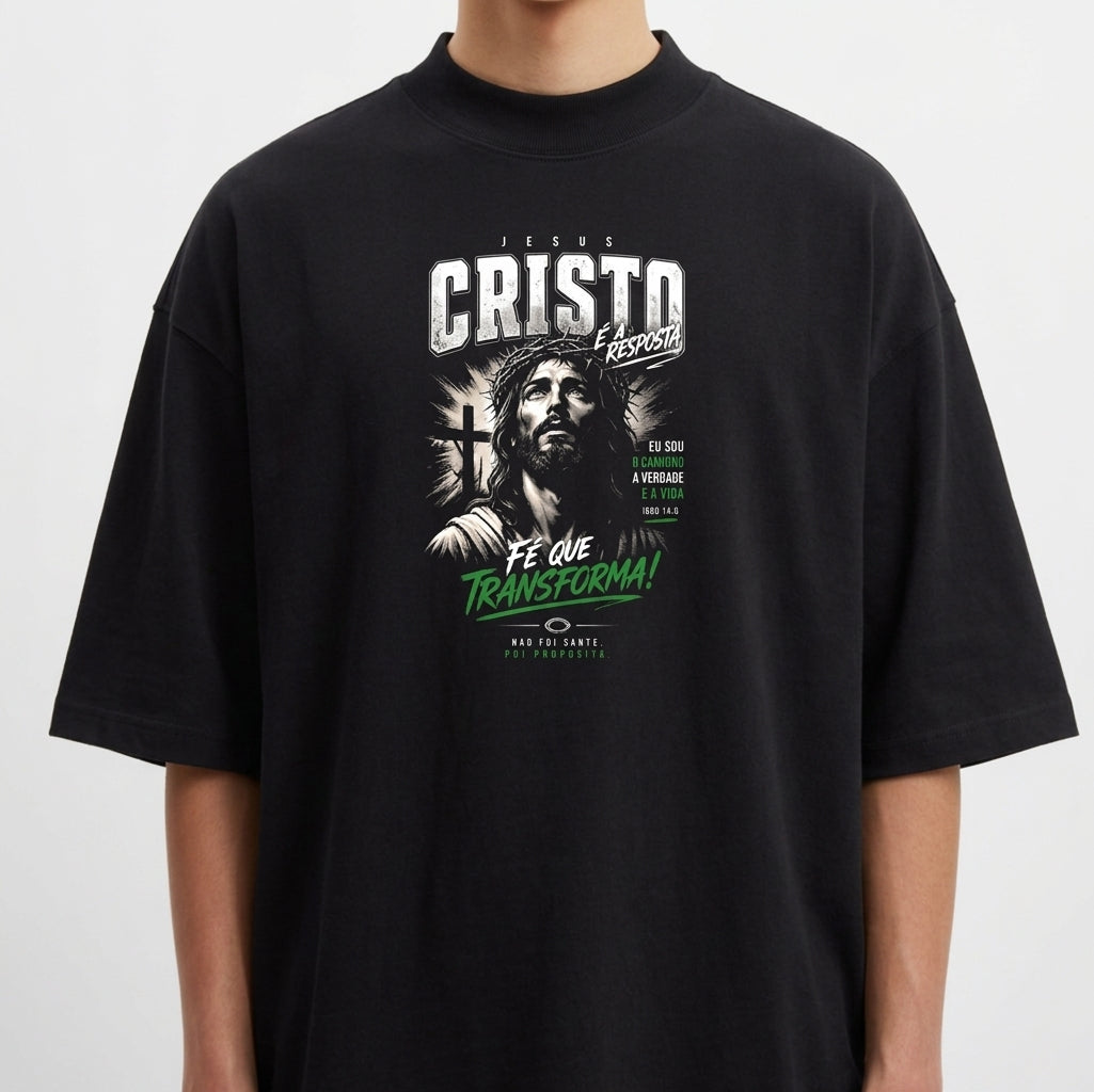 Camiseta com estampa frontal de figura religiosa ao lado de uma cruz, acompanhada de diversas frases em diferentes tipografias e tamanhos.