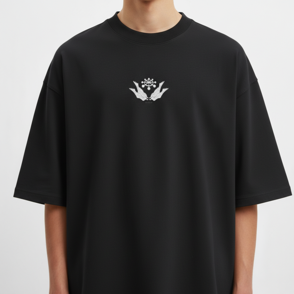 Camiseta com estampa frontal de mãos segurando uma flor estilizada e estampa traseira de design com asas, círculos e texto em estilo asiático.