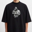 Camiseta com estampa frontal de um cantor segurando um microfone, exibindo detalhes de uma jaqueta e um nome logo abaixo em fonte estilizada.