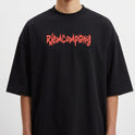 Camiseta com estampa frontal de texto em estilo grafite e estampa traseira de grupo fotográfico sobreposto a texto repetido "BE YOUR OWN REFERENCE".