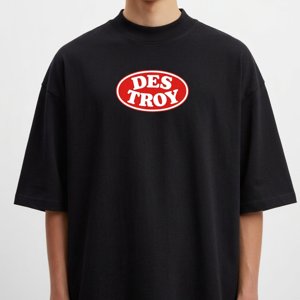 Camiseta com estampa frontal de logo oval "DESTROY" e estampa traseira de pacote com personagem animado, texto decorativo e bandeiras minúsculas.