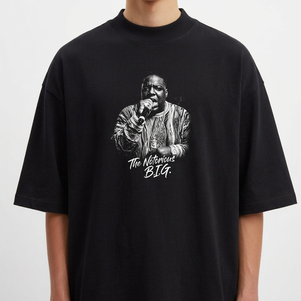 Camiseta com estampa frontal de um artista segurando um microfone e trajando roupa detalhada, acompanhada da inscrição estilizada "The Notorious B.I.G.".