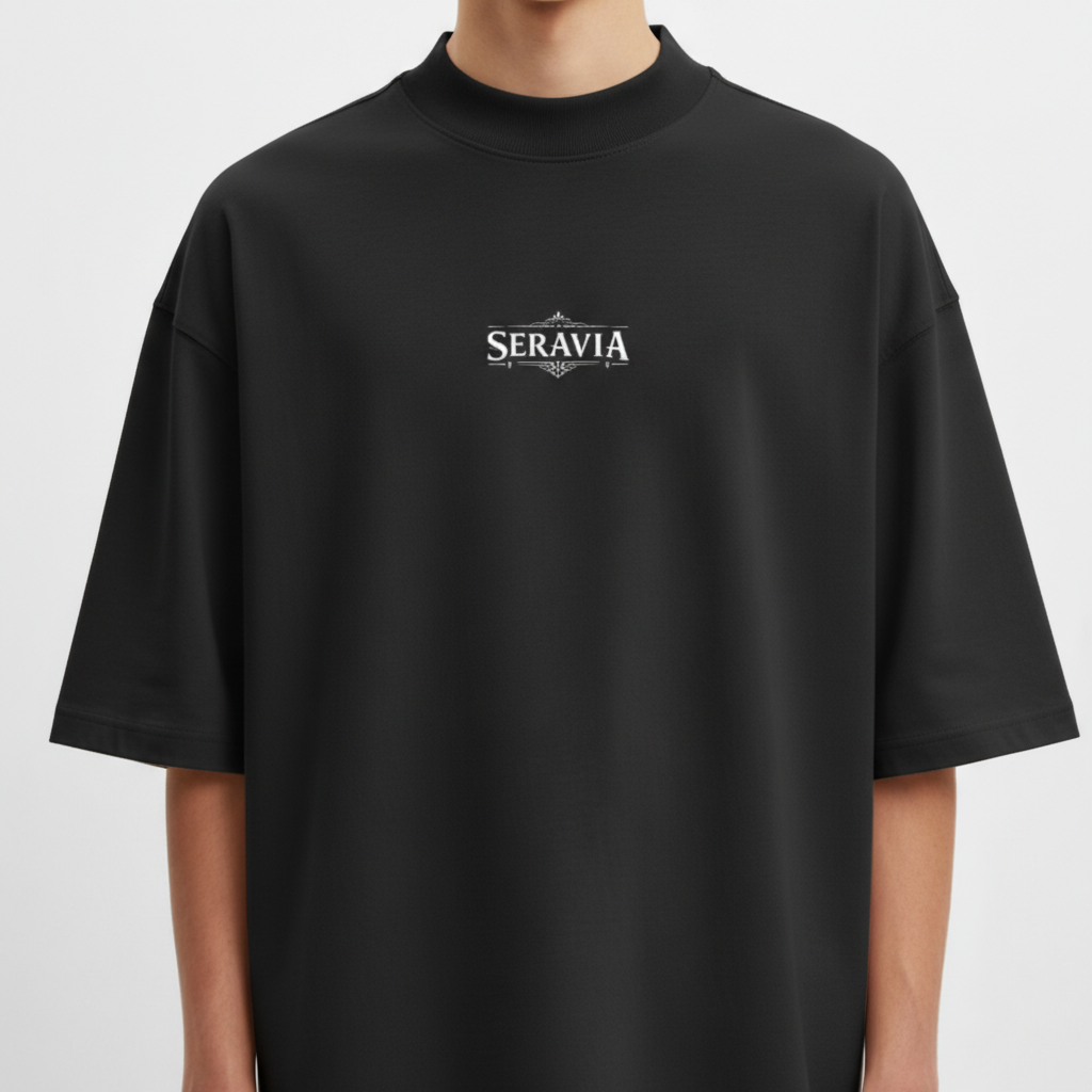Camiseta com estampa frontal de "Seravia" em letras estilizadas e detalhe ornamental, e estampa traseira de Anúbis, o deus egípcio, com asas e tochas.