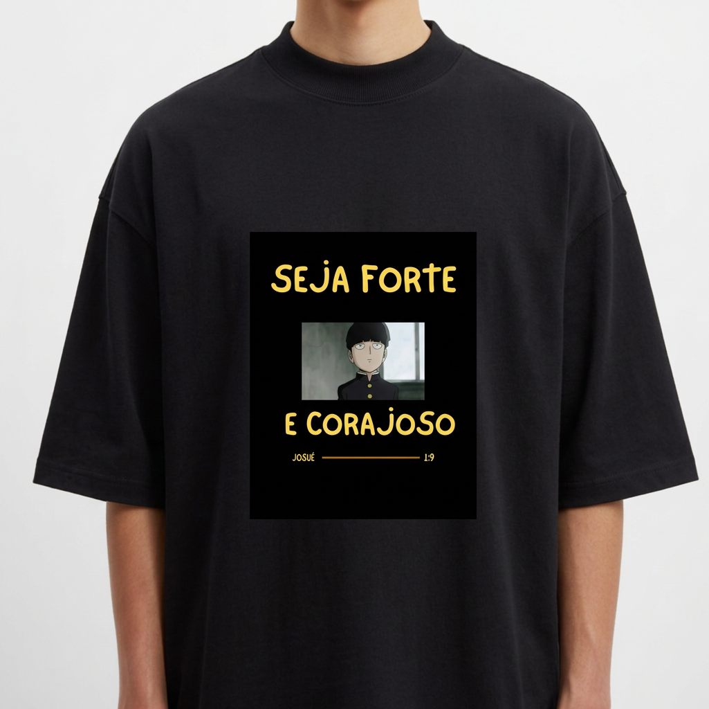 Camiseta com estampa frontal de personagem de cabelo curto em estilo desenho animado com mensagem inspiradora "SEJA FORTE E CORAJOSO" em letras destacadas.