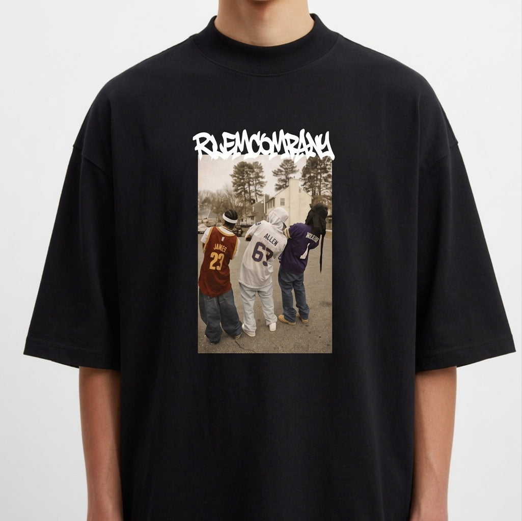 Camiseta com estampa frontal de três pessoas de costas usando camisetas de basquete, em frente a uma rua com árvores, sob um texto estilizado na parte superior.