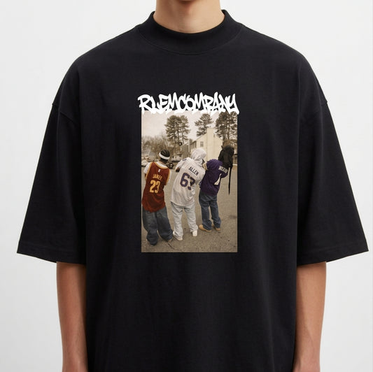 Camiseta com estampa frontal de três pessoas de costas usando camisetas de basquete, em frente a uma rua com árvores, sob um texto estilizado na parte superior.