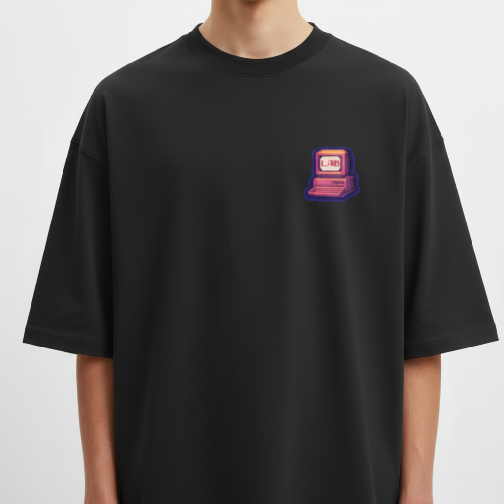 Camiseta com estampa frontal de ícone de computador retrô com a palavra "LAB" e estampa traseira de texto em camadas "LUGAR ABENÇOADO" com estrelas.