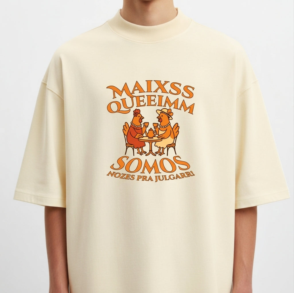 Camiseta com estampa frontal de duas galinhas sentadas à mesa com copos, cercadas por texto estilizado em torno delas.